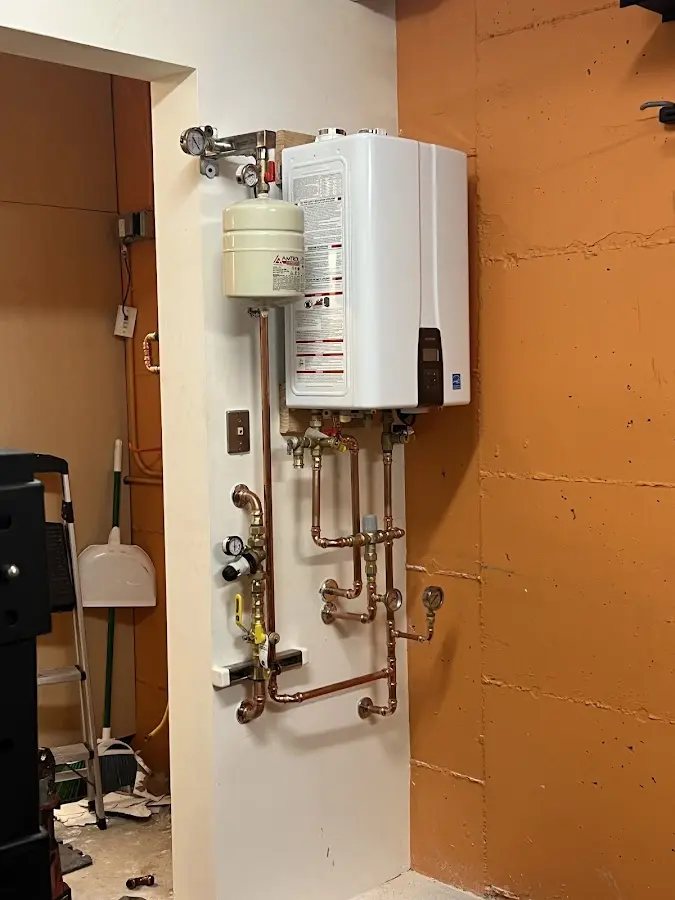 Plumbing technician inspecting water heater connections in Breckenridge Hills